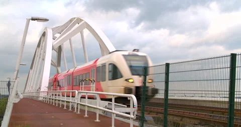 Dutch red train on modern bridge cloudy day Stock Footage 189336551