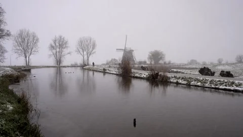 Dutch Windmill on the River Gein in Abcoude during Snowfall in the winter Stock Footage 327926428