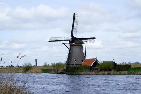 Dutch windmill standing next to polder water. Stock Photos