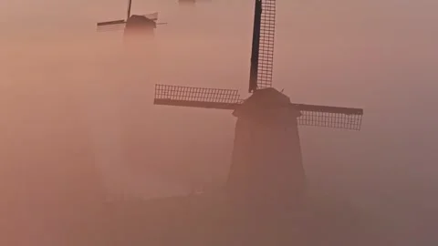 Dutch windmills emerging from thick morning fog Stock Footage 340347239