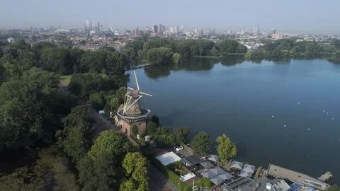 Dutch windmills in front of the Kralingse plas and the Rotterdam skyline Stock Footage 113215897
