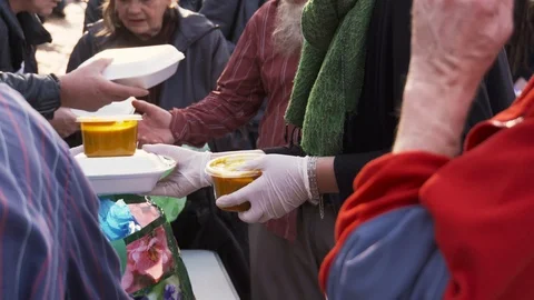 Dutiful volunteers giving away lunch meal packages to homeless people, Stock Footage