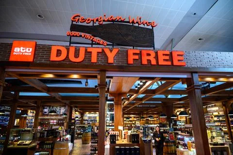 A duty-free shop interior with a bold 'DUTY FREE' sign and Georgian wine di.. Foto stock