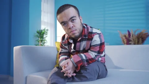 Dwarf young man at home looking at camera happily and resolutely Stock Footage 230974276