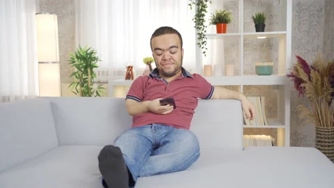 Dwarf young man using phone at home. Video stock 230965124
