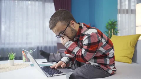 Dwarf young man working on laptop at home tired and sleepy. Stock Footage 230976185