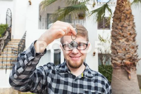 Dwelling, buying home, real estate and ownership concept - handsome man showing Stock Photos