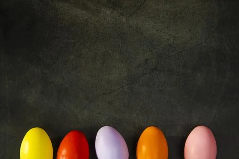 Dyed colorful Easter eggs on grey concrete background top view. Holiday banner Stock Photos
