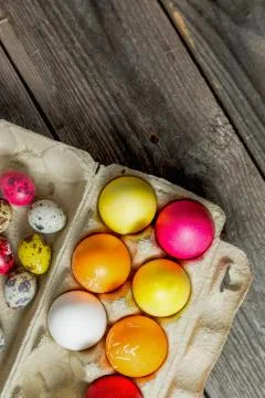 Dyed easter eggs in cardboard box on wooden background. Foto stock