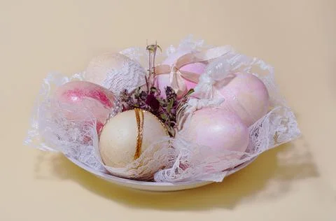 Dyed Easter eggs with lace on a plate Stock Photos