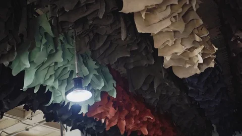 Dyed leathers are hanged for drying  under the factory ceiling. Stock Footage 121927294