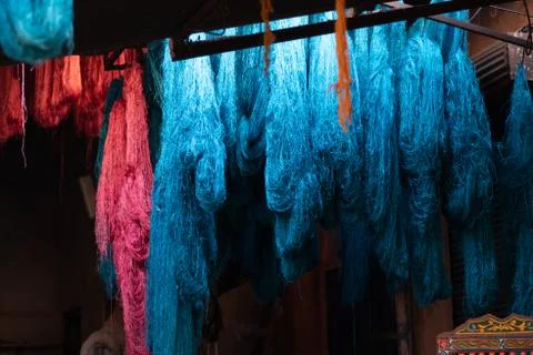 Dyed wool hanging to dry in souk in Marrakech Morocco, red, blue, yellow, gold Foto stock