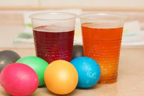 Dyeing multicolored easter eggs in coloring solutions Stock Photos