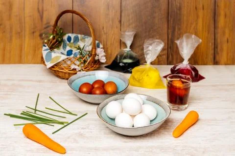 Dying eggs for Easter holiday. White and dyed eggs bowls arranged on vintage Foto stock