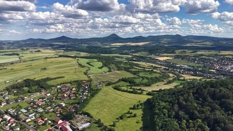 Dynamic aerial drone glide over rural valley with patchwork fields, small Stock Footage 347914040