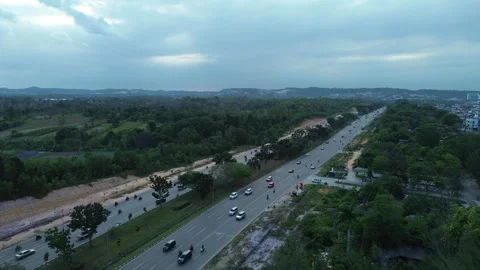 Dynamic aerial perspective of vehicles traversing a lush green arterial rou.. Stock Footage 339036556