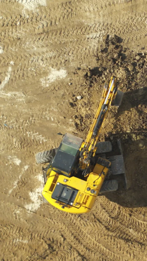 Dynamic aerial shots of an excavator digging at a construction site Stock Footage 328910372