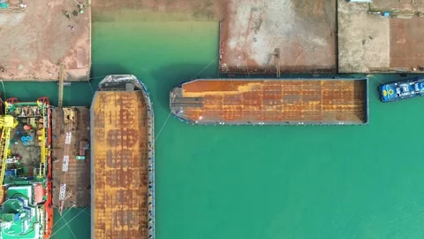 Dynamic aerial view of bustling maritime industrial operations: tugboats ma.. Video stock 325310064