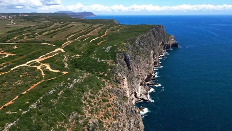 Dynamic Aerial View of Coastal Cliffs and Ocean Along Rugged Shoreline Vídeos de archivo 336746534