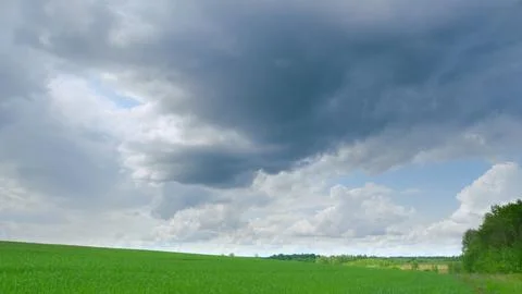 Dynamic and Beautiful Cloud Patterns Over Lush Green Fields in the Atmosphere Al 스톡 사진