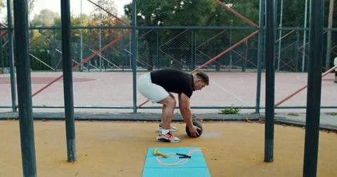 Dynamic and Engaging Outdoor Workout Incorporating Medicine Ball Training Stock Footage 317836469