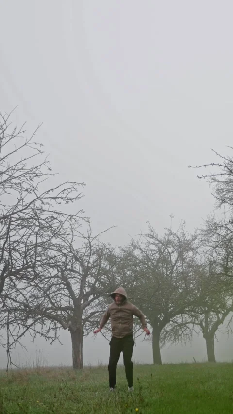 Dynamic and Exciting Jumping Action Set in a Misty and Foggy Orchard Landscape Stock-Footage 308371235