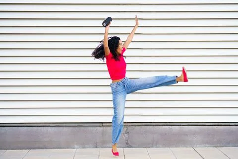 Dynamic and Joyful Dance Pose Captured Against a Striped Background for a Vivid Stock-Fotos