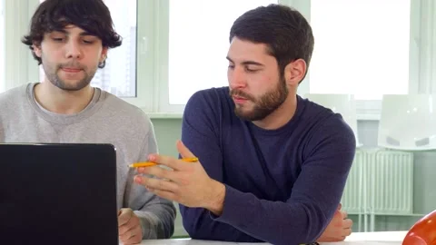 Dynamic architects collaborating over a laptop in a modern office Stock Footage 311985570