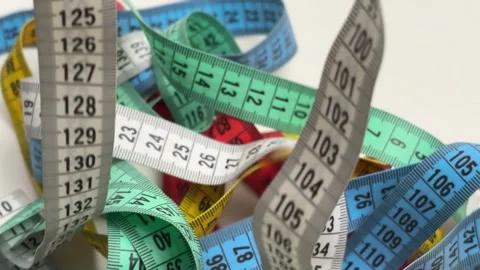 Dynamic background of multiple colorful measuring tapes falling and overlapping Video stock 336626977