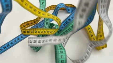 Dynamic background of multiple colorful measuring tapes falling and overlapping Stock Footage 336627011