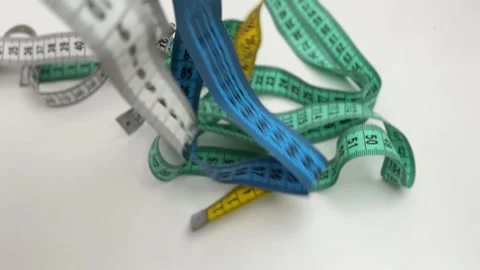 Dynamic background of multiple colorful measuring tapes falling and overlapping Stock Footage 336627017