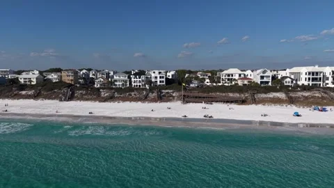 Dynamic backward drone fly of coastline suburban community with resting people Видео 331066965