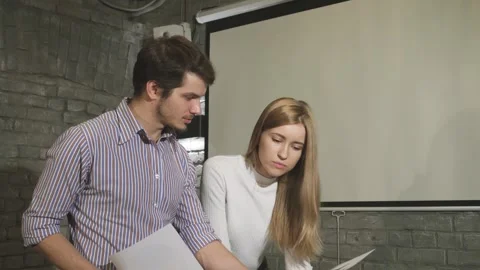 Dynamic business colleagues collaborating on paperwork in a modern office Stock Footage 311984207