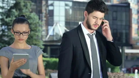 Dynamic business couple collaborating on a tablet while taking calls Stock Footage 311650078