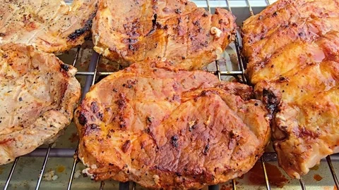 Dynamic camera move along electric grill grate with delicious meat steaks Stock Footage 344702873