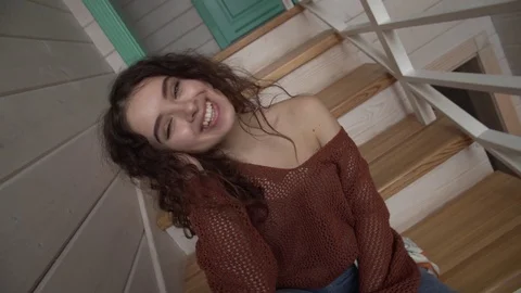 Dynamic camera moves girl smiling sitting on the stairs and laughing posing. Stock Footage 128648175