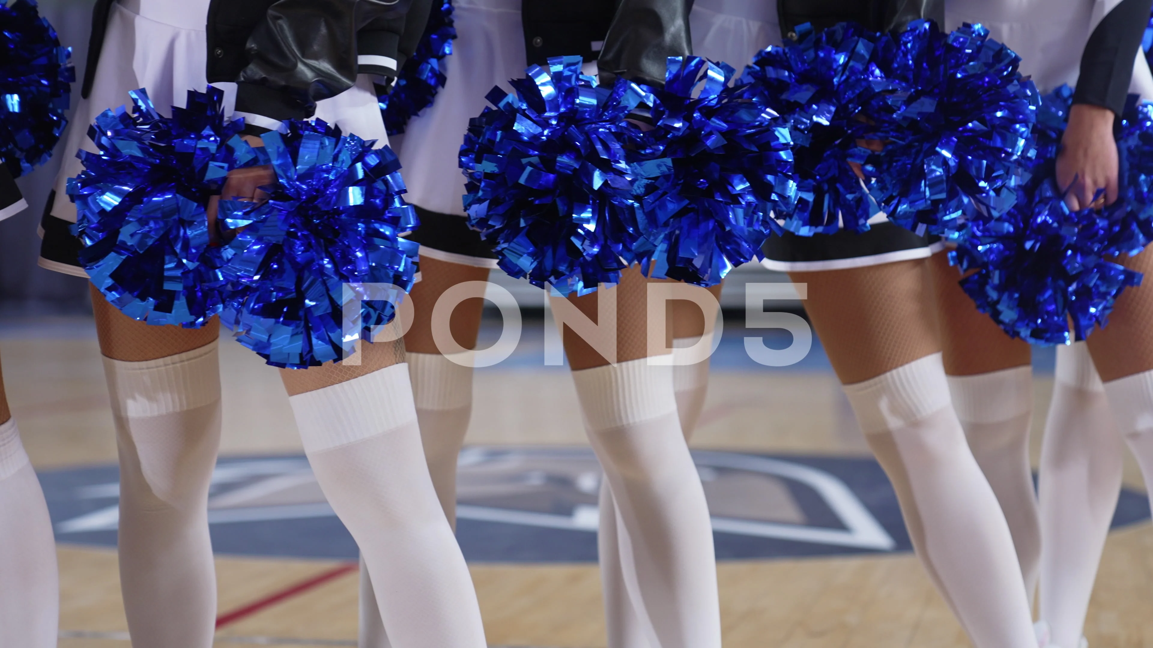 A cheerleader shakes her pom-poms smiles and encourages action