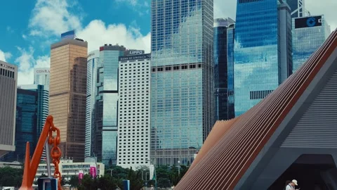 A dynamic cityscape in Hong Kong featuring striking copper sculpture against a Stock Footage 338311385
