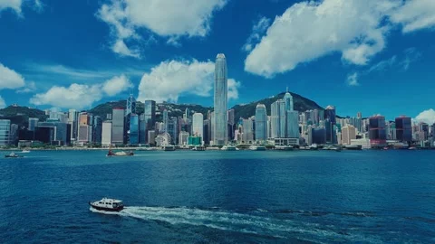 A dynamic cityscape with towering skyscrapers and lush green hills framed by a Stock Footage 338310995