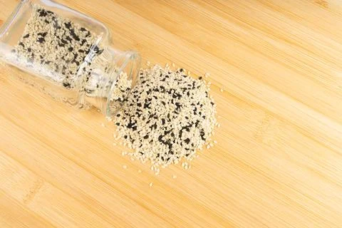 Dynamic Close-up of Black and White Sesame Seeds Gracefully Spilling from a.. Stock Photos