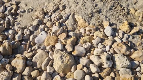 Dynamic close-up drone view of rocky shoreline with textured stones Stock Footage 322161115