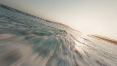Dynamic Close-up of Ocean Wave Rolling onto Shore at Golden Sunrise Hour Stock Footage 319295232