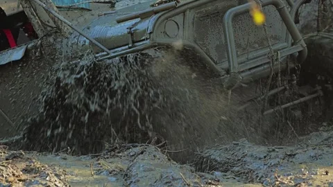 Dynamic close-up of a powerful 4x4 vehicle's tire churning through thick mud Stock Footage 344876012