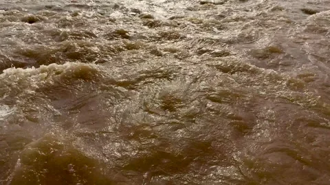 Dynamic closeup of turbulent muddy river water with swirling patterns and r.. Stock Footage 339425618