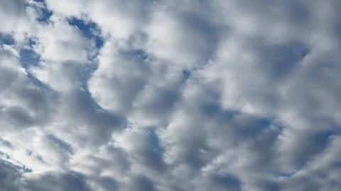 Dynamic cloud patterns gracefully fill the sky on a clear afternoon. The Stock Footage 318784230