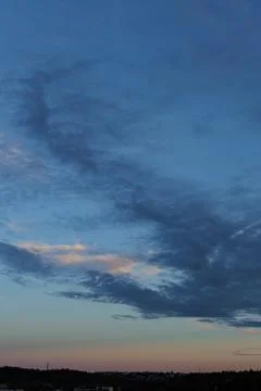 Dynamic clouds color the sky at sunset Stock Photos
