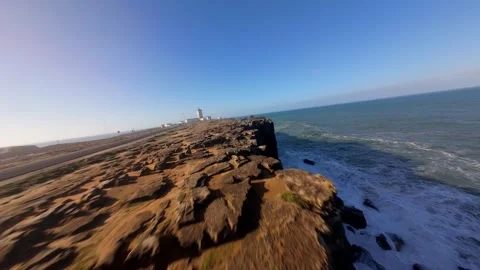 Dynamic coastal drive with lighthouse in background Video stock 346077170