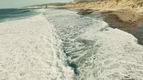 Dynamic coastal scene with powerful waves rolling toward shore Stock Footage 339789935