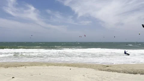 A dynamic coastal scene showing numerous kiteboarders catching waves on a b.. Stock Footage 337354308