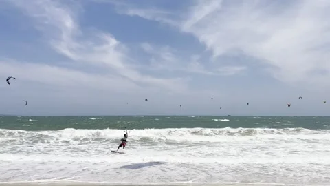 A dynamic coastal scene showing numerous kiteboarders catching waves on a b.. Stock Footage 337354309